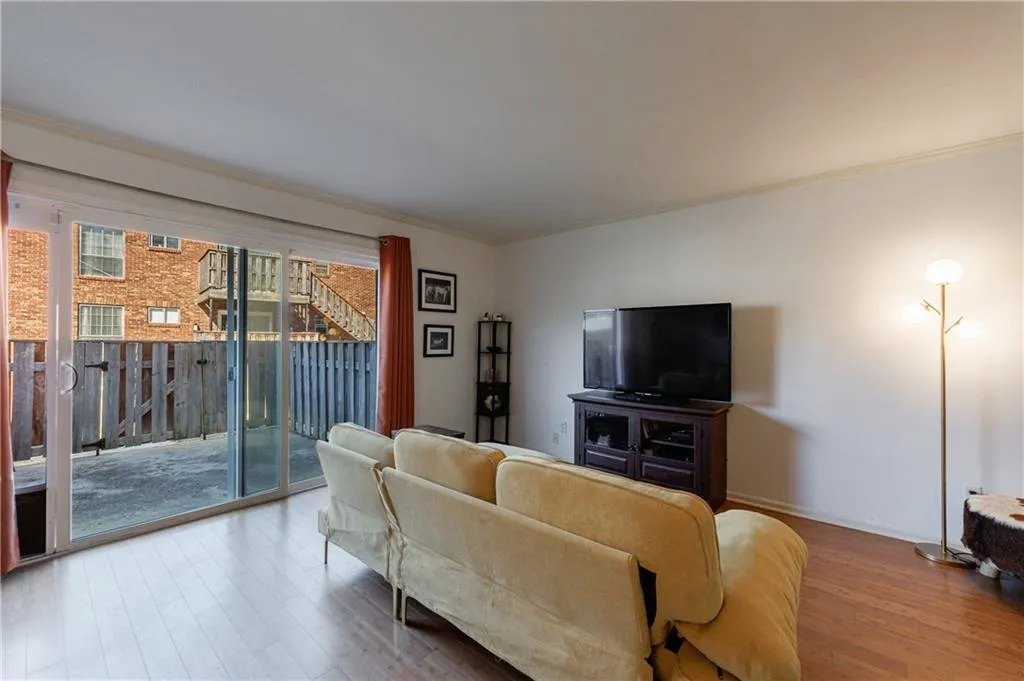 Living room with wood finished floors and ornamental molding