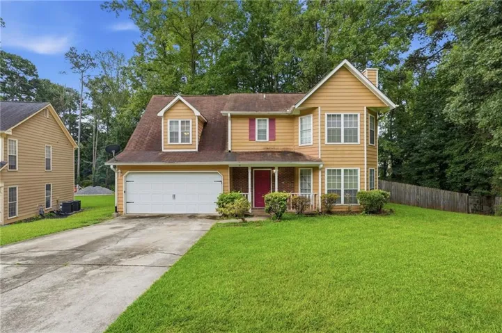 Two-story residence featuring a two-car garage, dormer windows, and a covered front entry