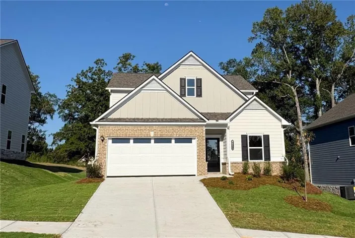 Two-story residence featuring a brick and siding exterior, a two-car garage, and a concrete driveway