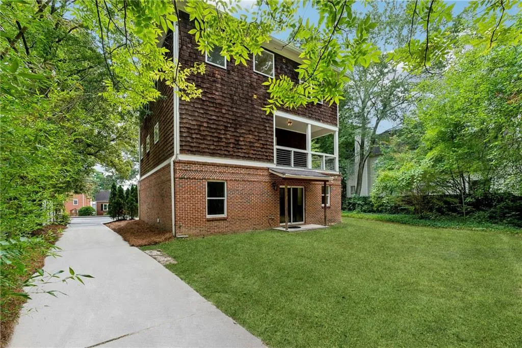 View of front facade with a balcony and a front lawn