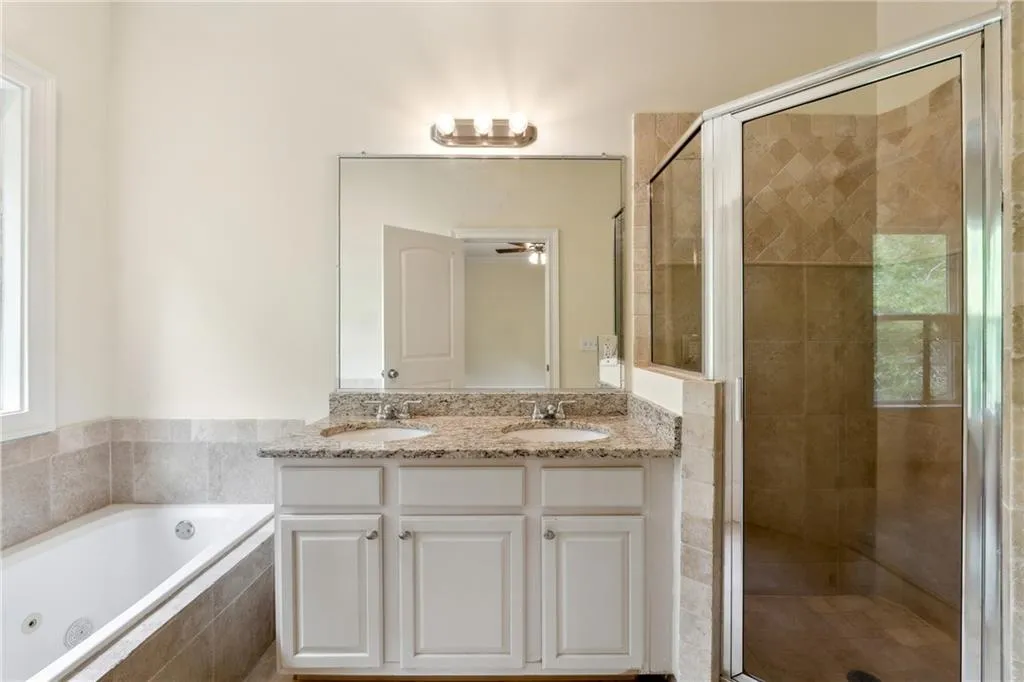 Bathroom with independent shower and bath, ceiling fan, and double sink vanity