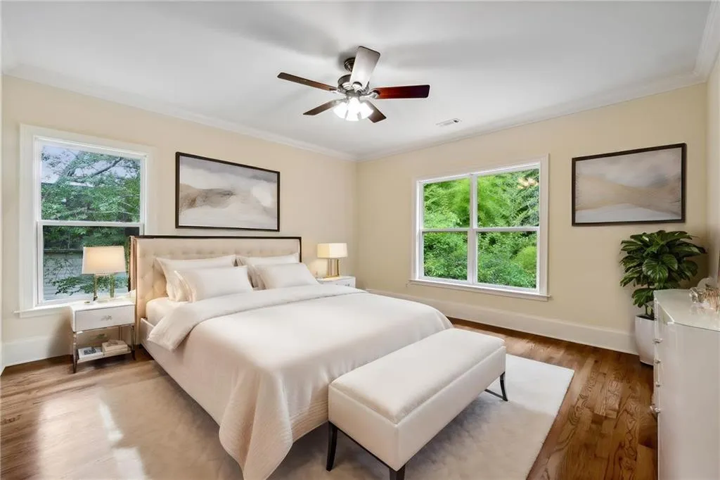 Bedroom with multiple windows, ceiling fan, hardwood / wood-style floors, and crown molding