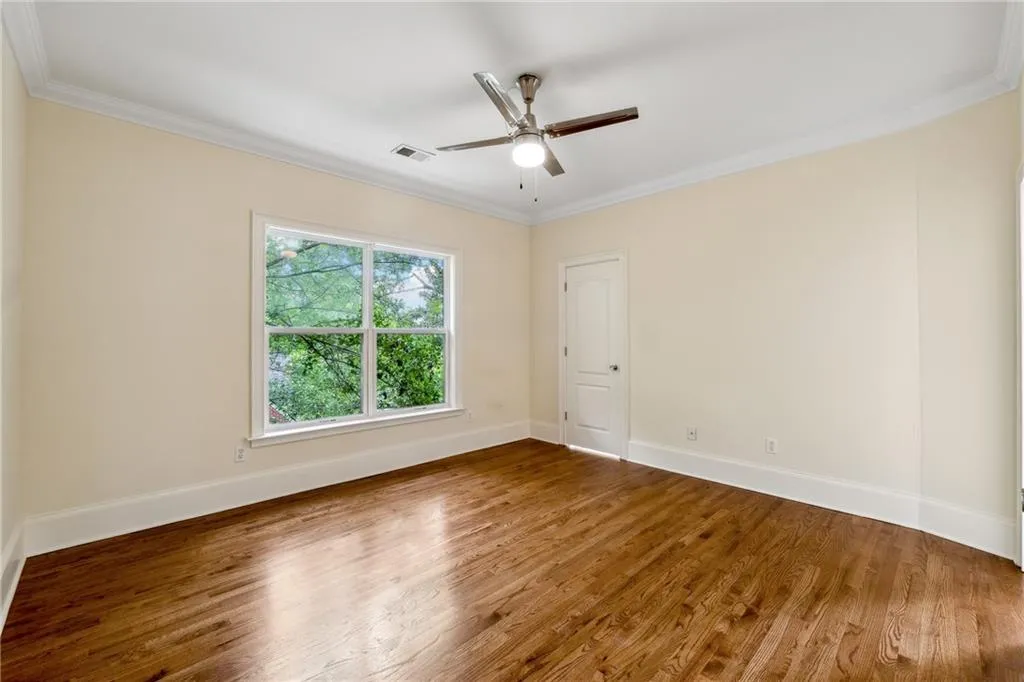 Spare room featuring ornamental molding, hardwood / wood-style flooring, and ceiling fan