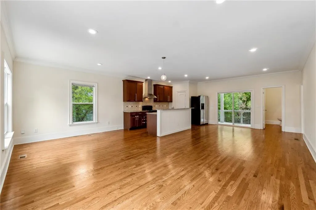 Unfurnished living room with light hardwood / wood-style floors and crown molding