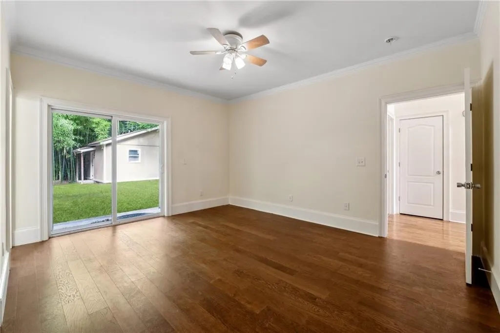 Unfurnished room featuring wood-type flooring, ornamental molding, and ceiling fan