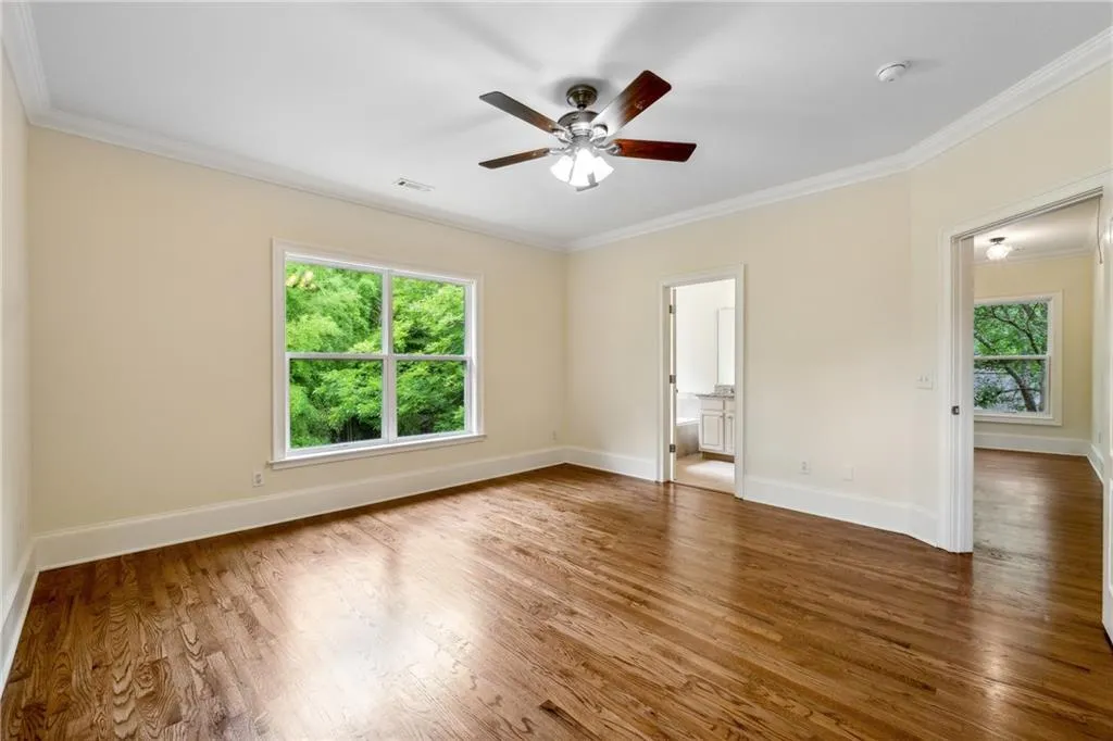 Spare room featuring dark hardwood / wood-style floors, ceiling fan, and ornamental molding