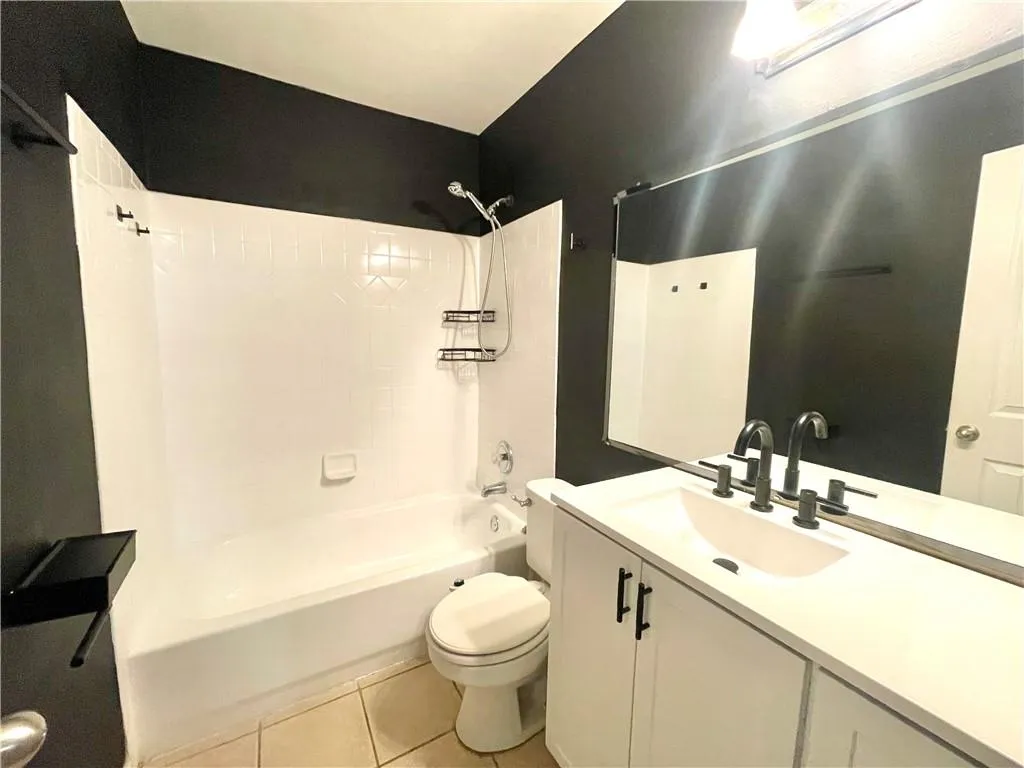 Full bathroom featuring vanity, toilet, tub / shower combination, and tile patterned flooring