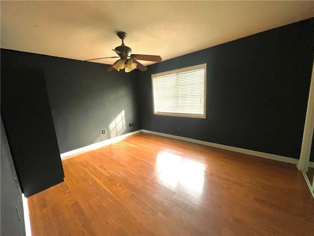 Unfurnished room with hardwood / wood-style floors and ceiling fan