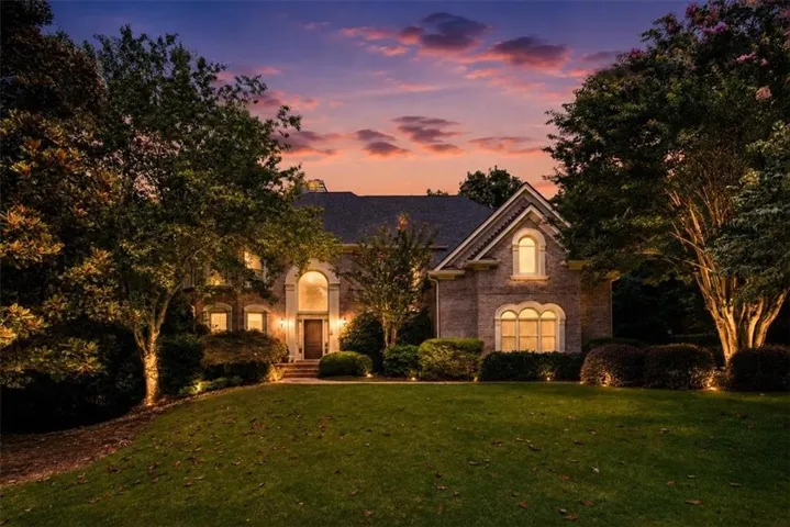 Brick exterior residence featuring a gabled roofline and arched windows