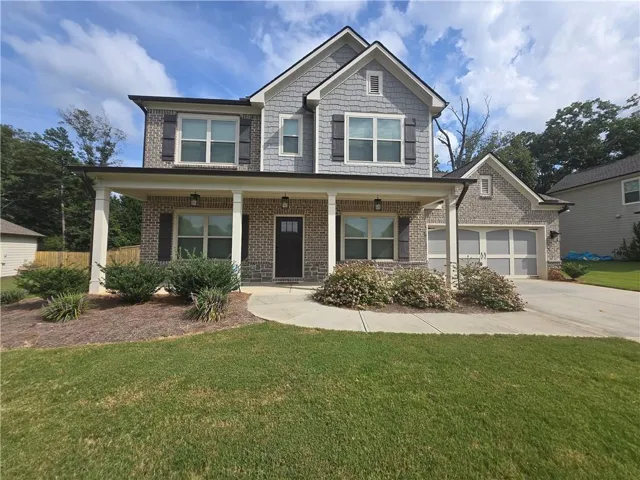 Brick exterior with shingle accents and a covered front porch