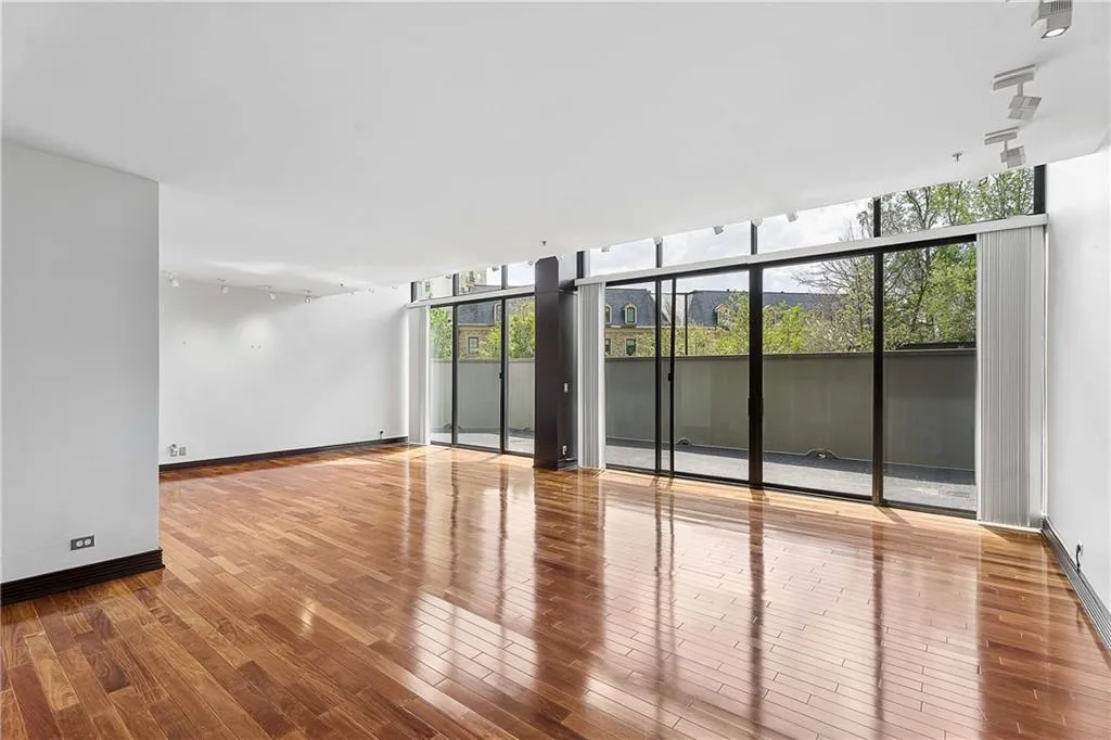 Empty room featuring expansive windows and wood-type flooring