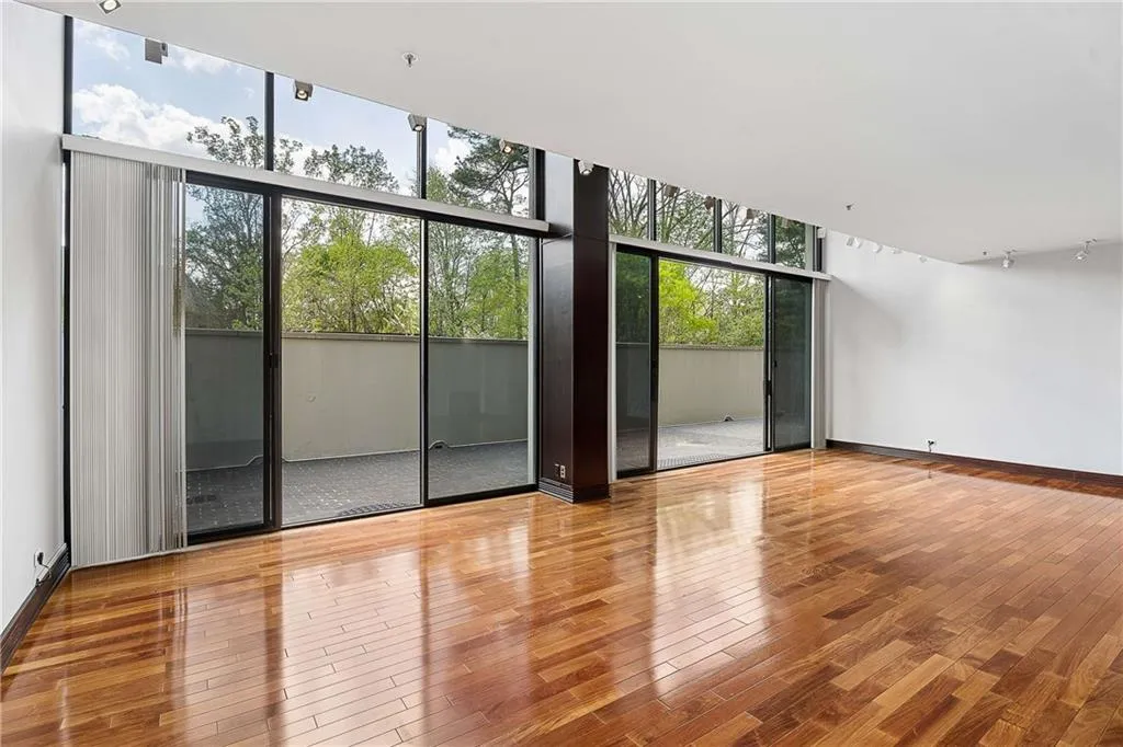 Empty room featuring expansive windows and hardwood / wood-style flooring