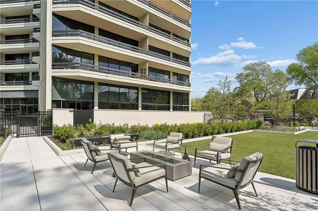 View of patio with an outdoor living space with a fire pit and a gate