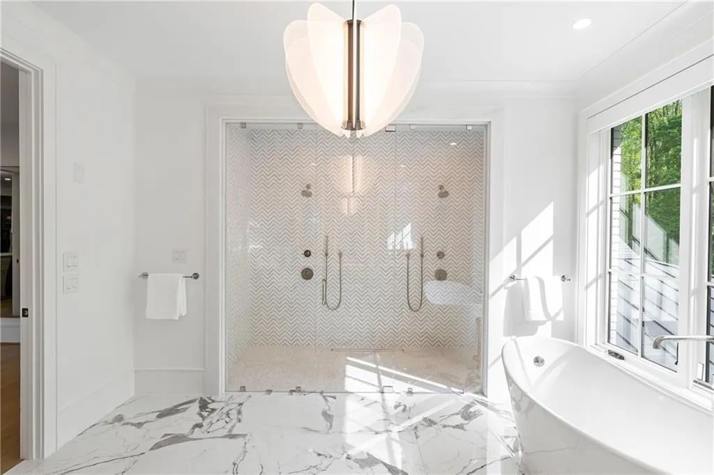 Primary spa bath with extra large glass encased shower and soaking tub.