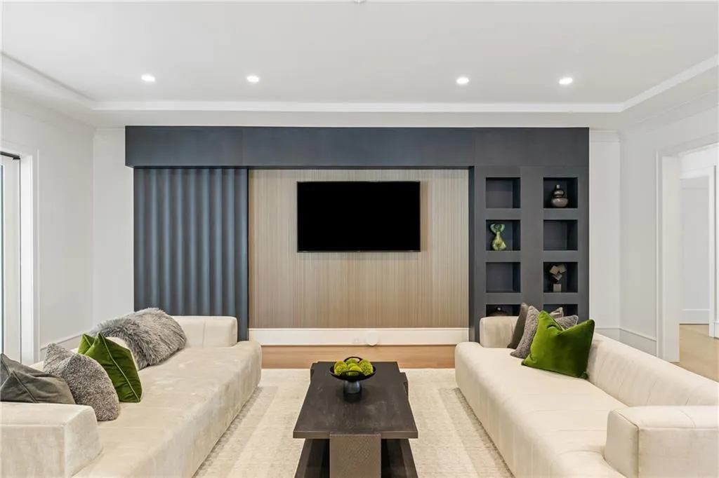 The formal living area showcases artistic millwork and has sliding doors that disappear into the walls and open to a large screened in porch with serene view of the tree-lined property.