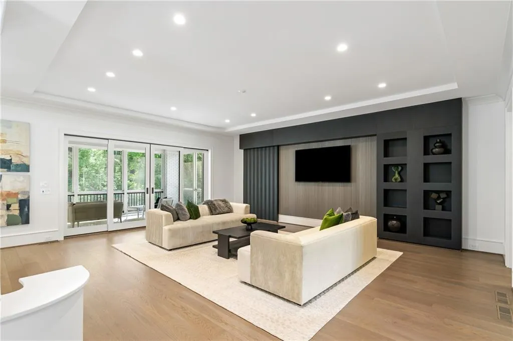 The formal living area showcases artistic millwork and has sliding doors that disappear into the walls and open to a large screened in porch with serene view of the tree-lined property.