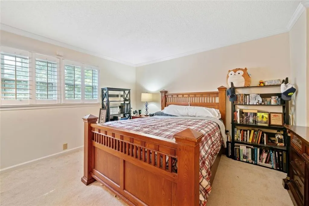 Primary Bedroom featuring ornamental molding, a textured ceiling, and light carpet