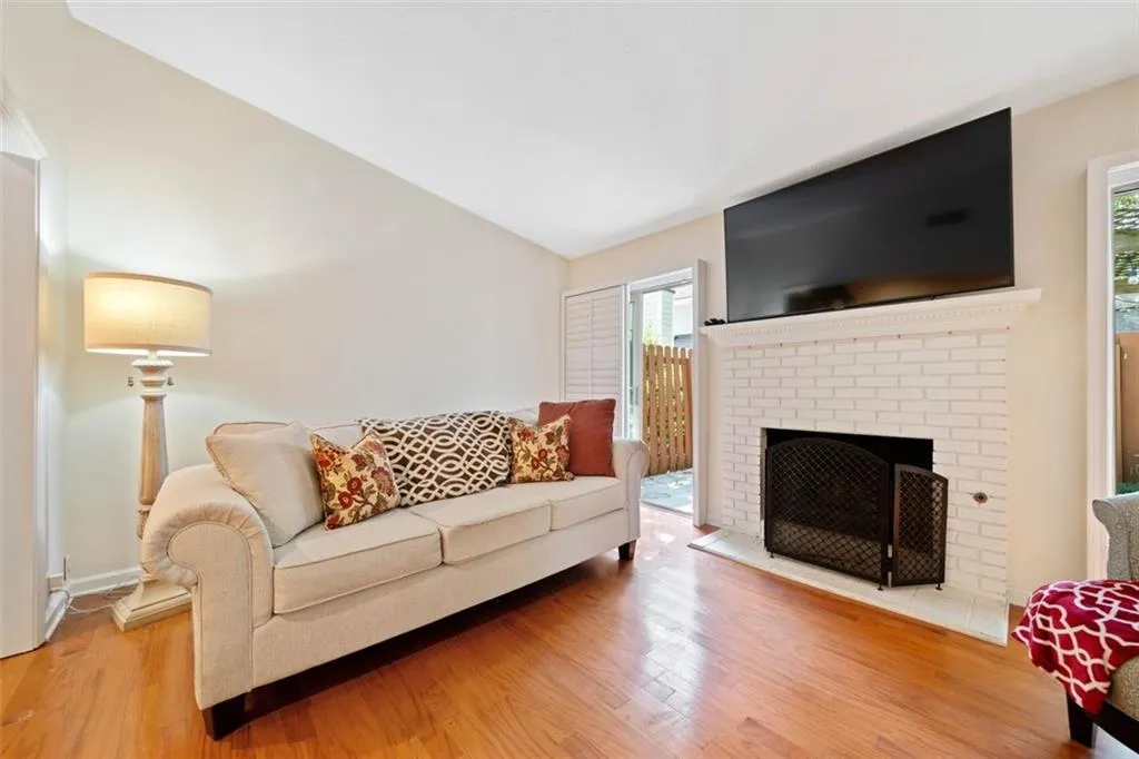 Living room with hardwood / wood-style flooring, a fireplace, and lofted ceiling