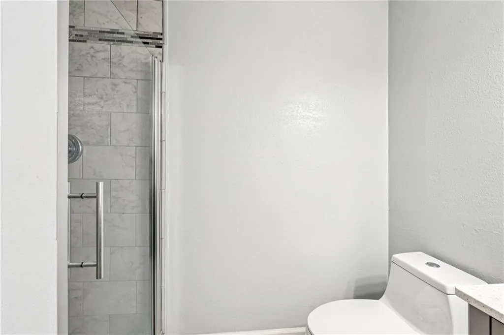 Full bath with a shower stall and vanity