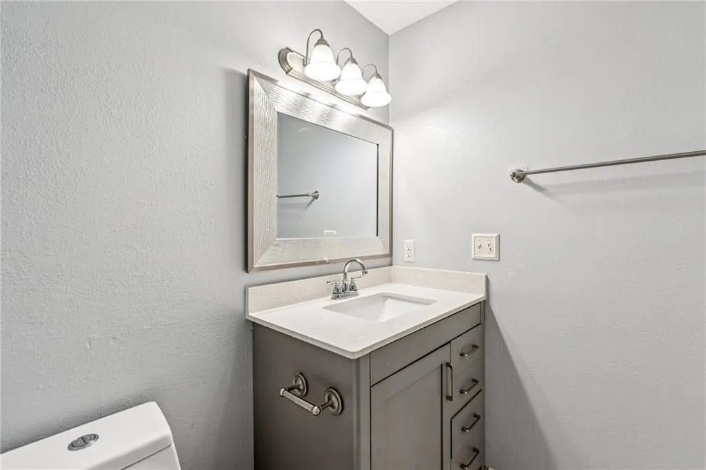 Half bath with vanity and a textured wall