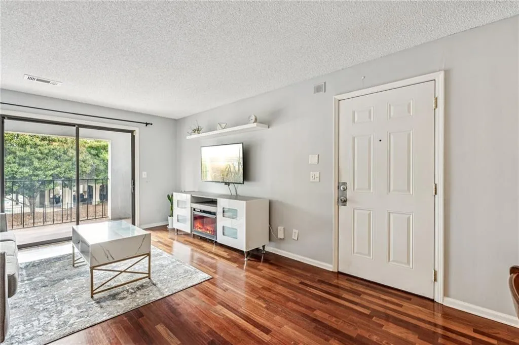 Living room with a textured ceiling and wood finished floors