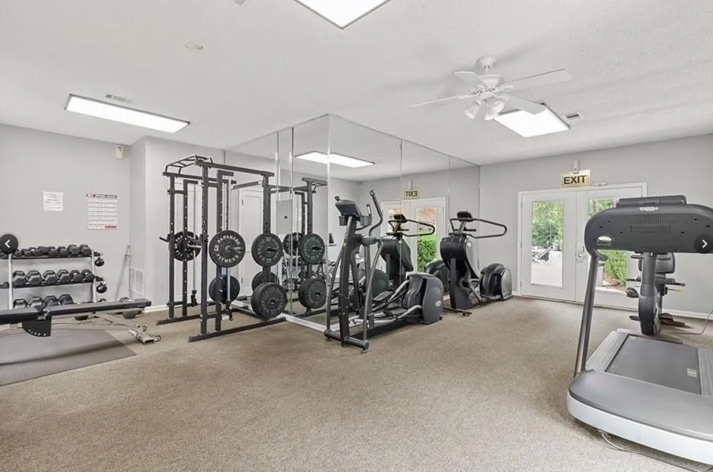 Exercise room featuring a ceiling fan, carpet floors, and french doors