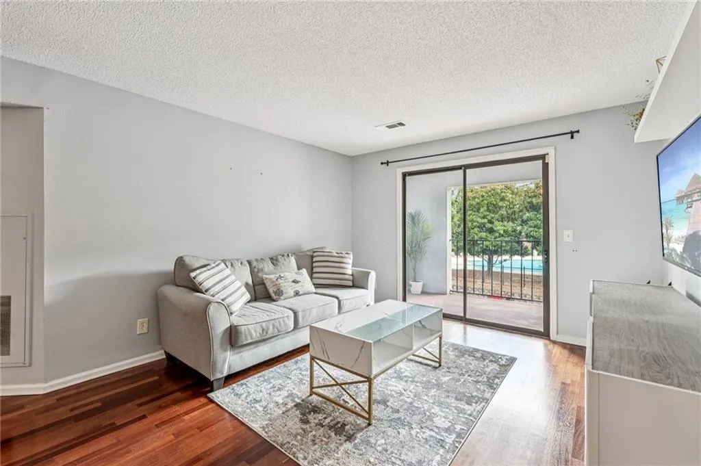 Living room with a textured ceiling and wood finished floors