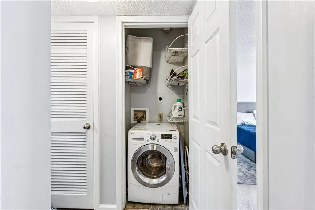 Washroom with washer / dryer and a textured ceiling