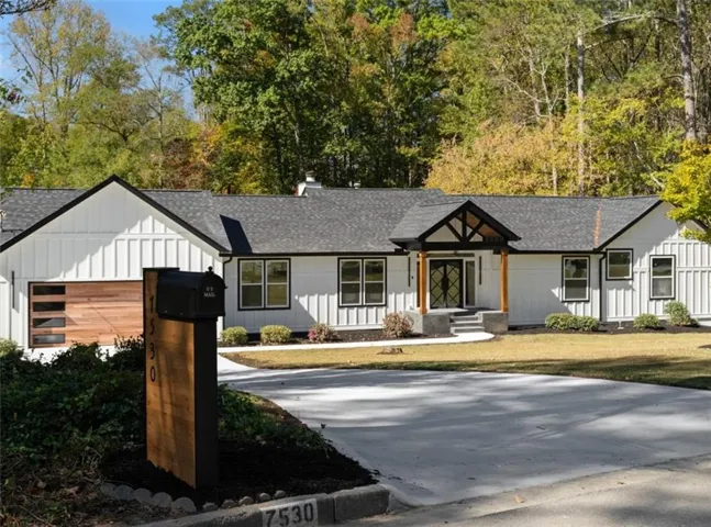 Modern farmhouse style home with roof with shingles, board and batten siding, and a porch