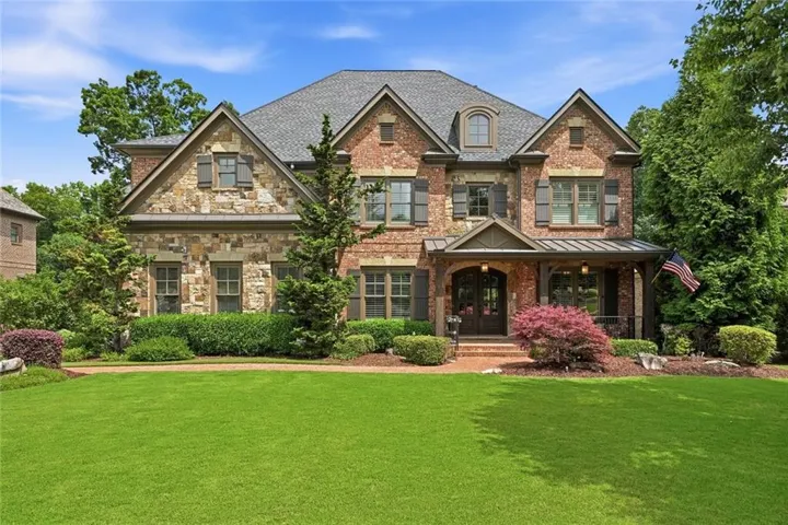 Stately residence featuring a brick and stone facade with multiple gables