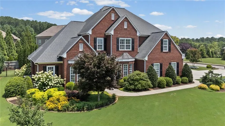 Brick exterior featuring multiple gables, white trim, and black window shutters