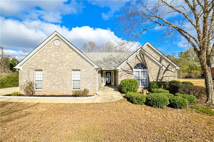View of front facade with brick siding and a front lawn