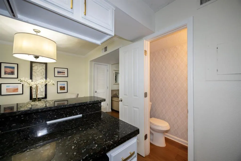 Bathroom with wood finished floors, vanity, crown molding, and electric panel
