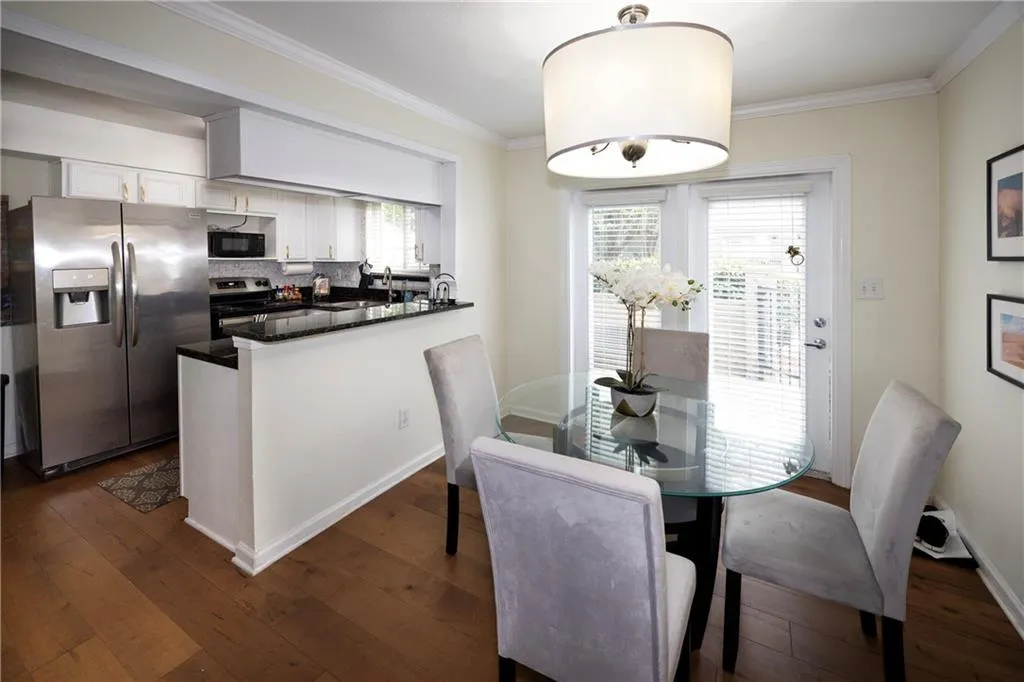 Dining space featuring crown molding and dark wood finished floors