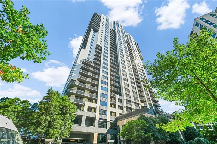 Modern high-rise residential building featuring multiple balconies and a multi-level base