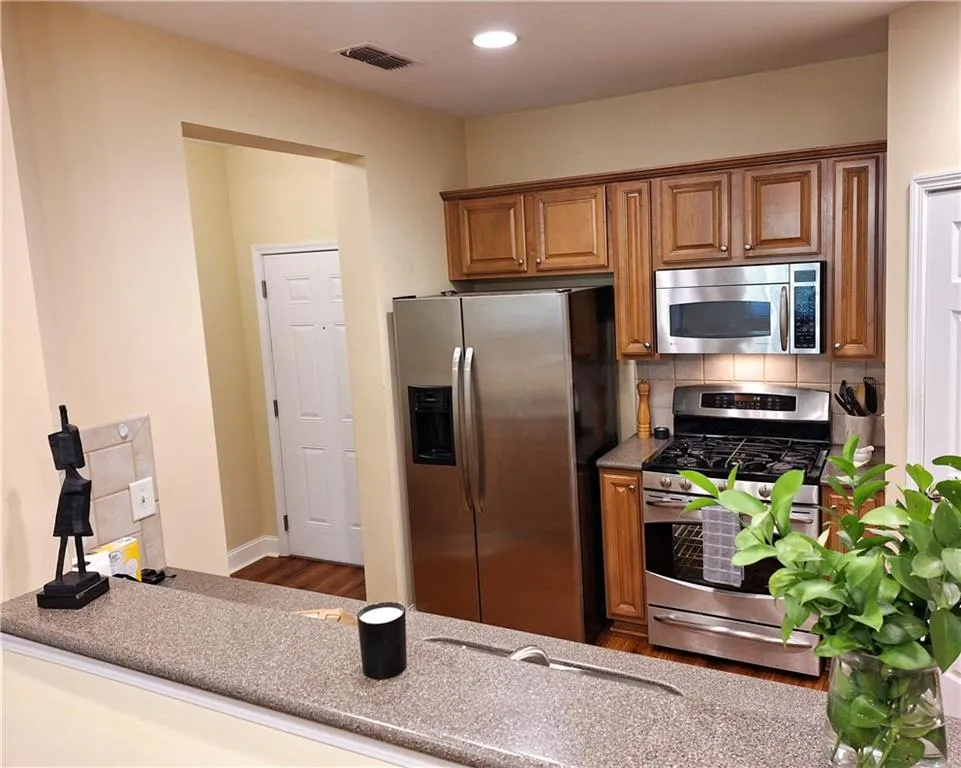 Another view of Kitchen from Dining Area, with entry door shown to the rear on left.