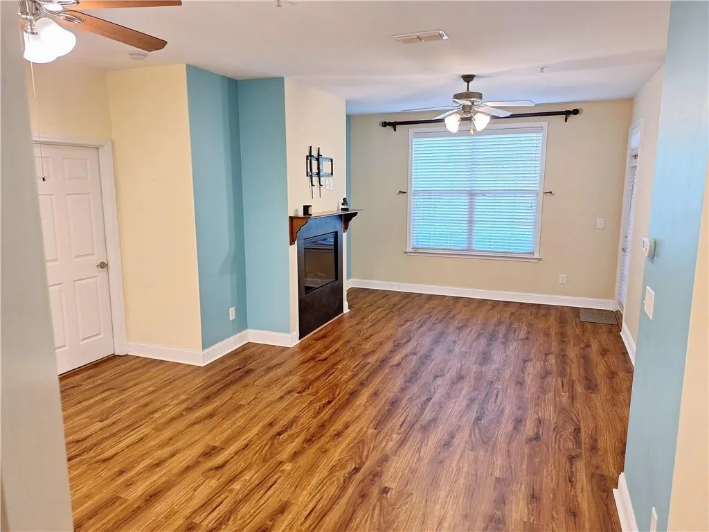 Open Concept floor plan, with Dining Area in foreground and Living Area with Fireplace to the rear. (Hardwoods were installed approx. 3 years ago, however, as home has not been occupied are in 
