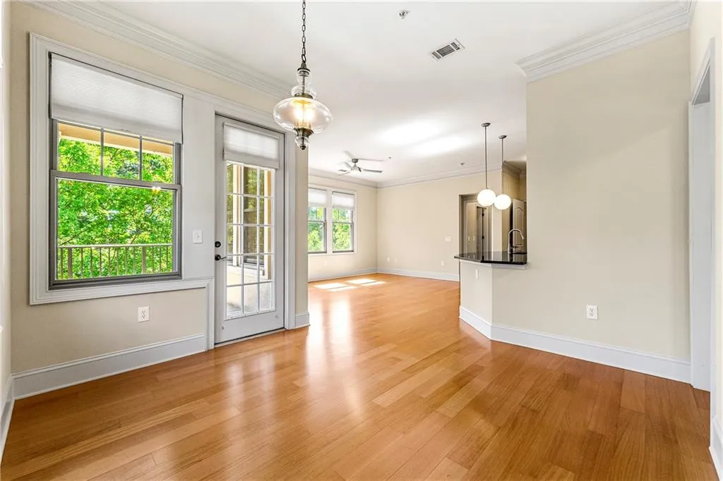 Unfurnished room featuring baseboards, light wood-style flooring, crown molding, and a ceiling fan
