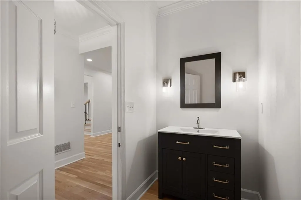 Powder Room off Foyer - Dark wood vanity with a white countertop and rectangular undermount sink