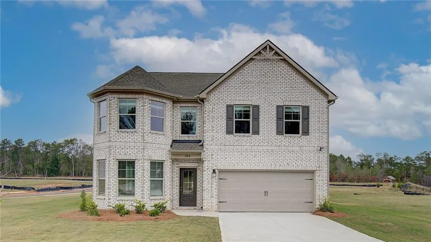 View of front of house with a garage and a front lawn