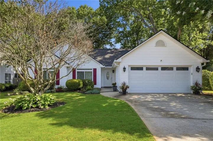 White siding exterior with a two-car garage featuring transom windows