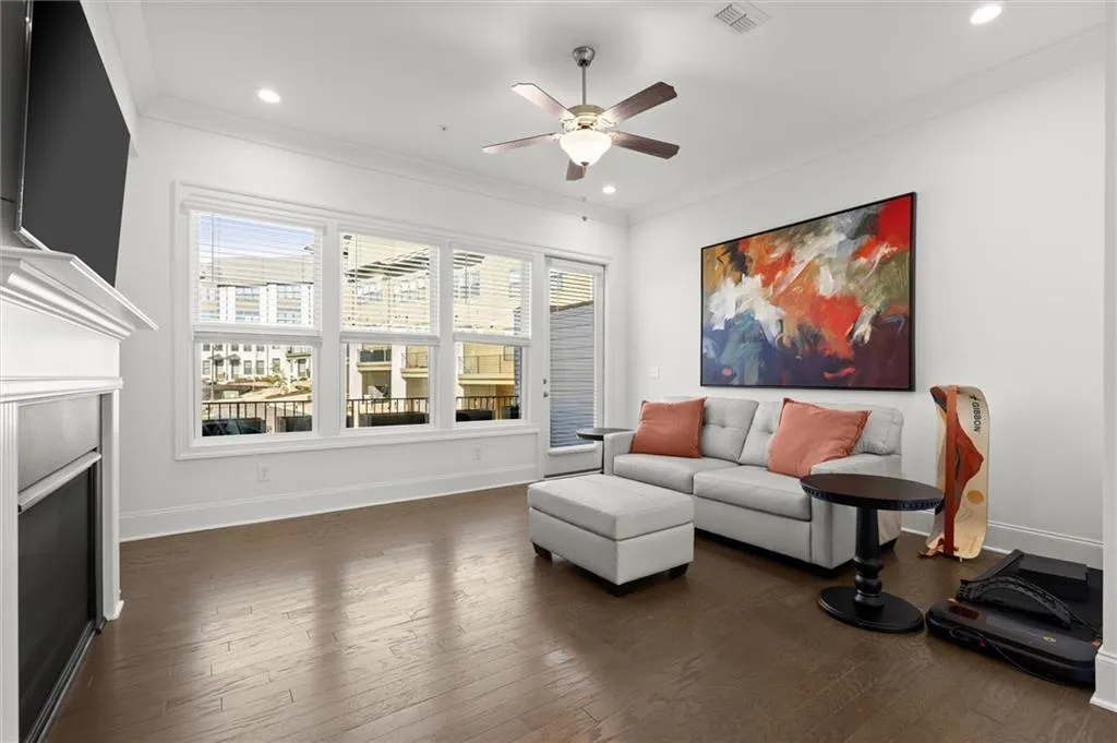 Family area featuring dark wood-type flooring, crown molding, ceiling fan, recessed lighting, and a fireplace