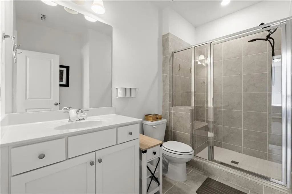 Bathroom with a shower stall, vanity, and light tile patterned floors