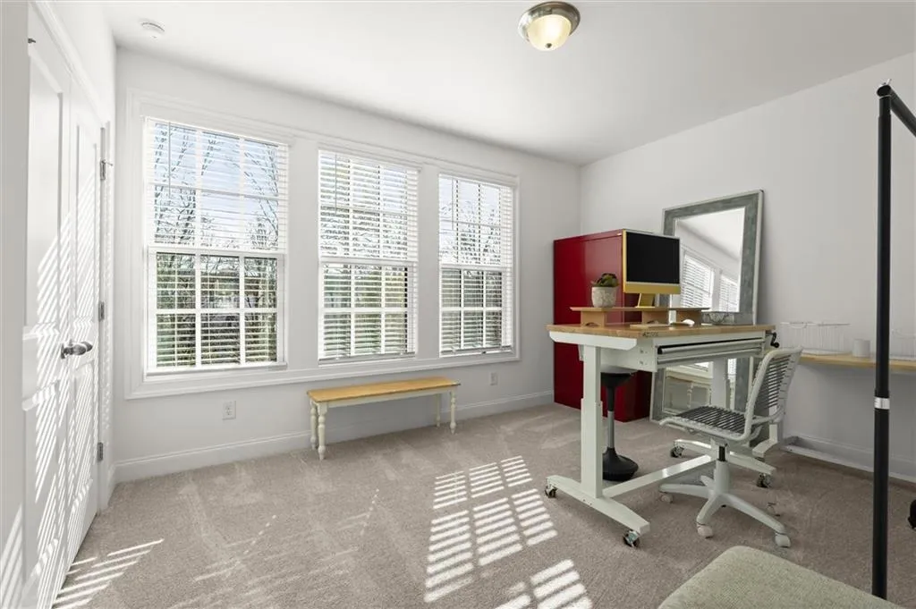 Home office featuring light colored carpet and baseboards