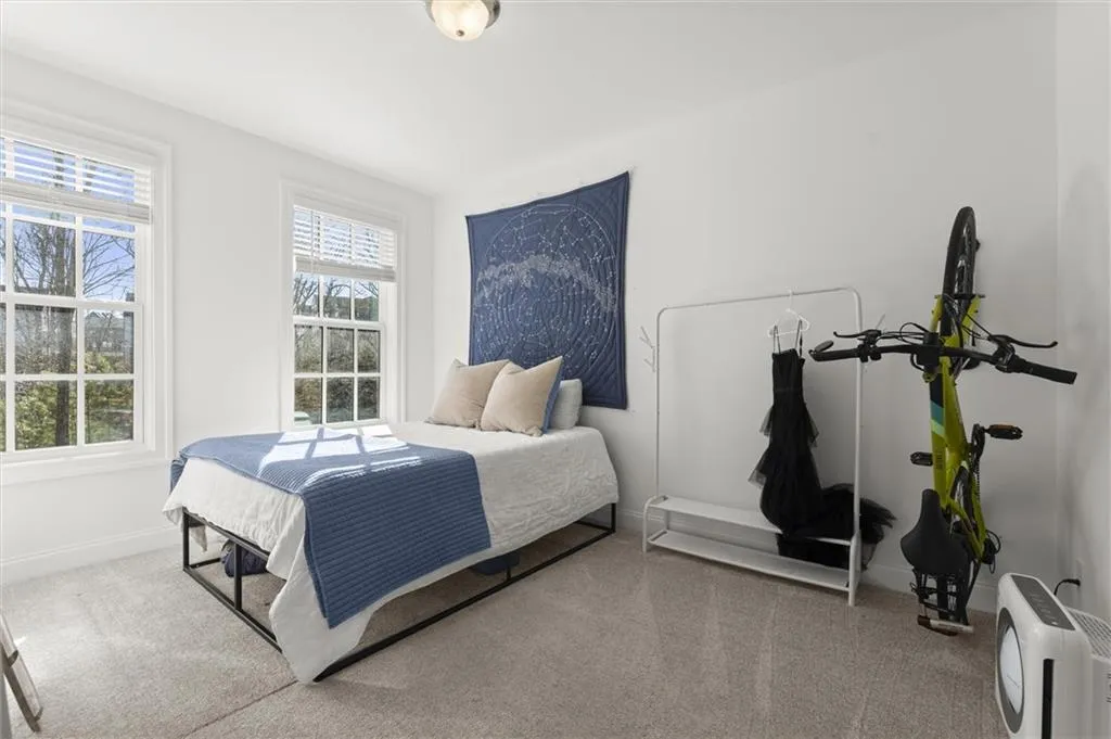 Carpeted bedroom featuring baseboards and heating unit