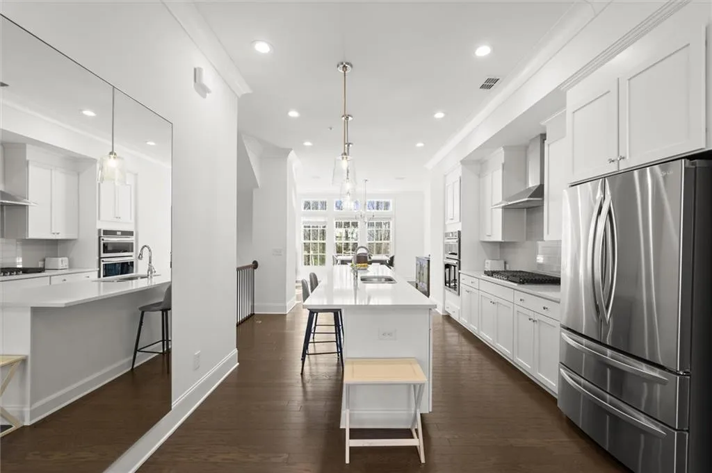 Kitchen featuring tasteful backsplash, appliances with stainless steel finishes, a breakfast bar, ornamental molding, and a large island