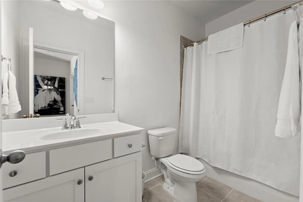 Full bathroom with light tile patterned flooring, vanity, and shower / bathtub combination with curtain