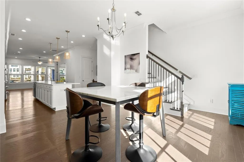 Dining area featuring crown molding, recessed lighting, dark wood finished floors, stairs, and a chandelier