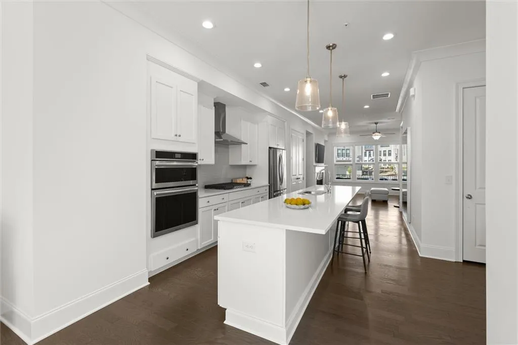 Kitchen with white cabinetry, recessed lighting, a kitchen bar, crown molding, and a large island