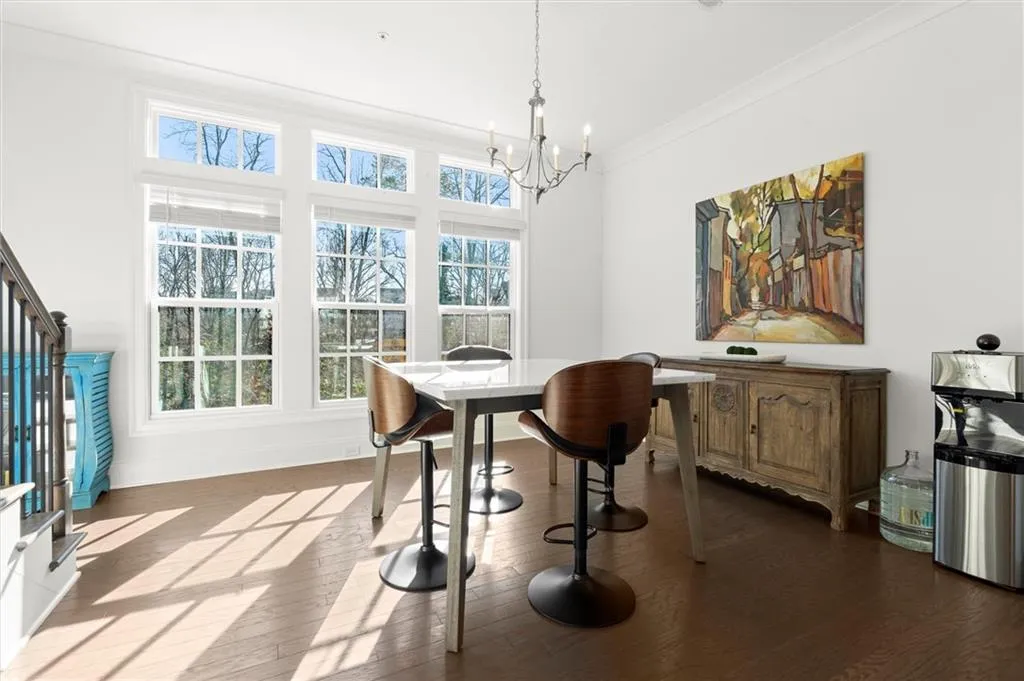 Dining area featuring ornamental molding, a chandelier, and dark wood-style flooring